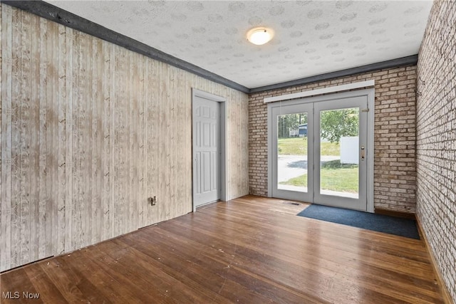 16792 Gonzales Ave, East Liverpool, OH 43920 - spare room with wood-type flooring, brick wall, and wood walls