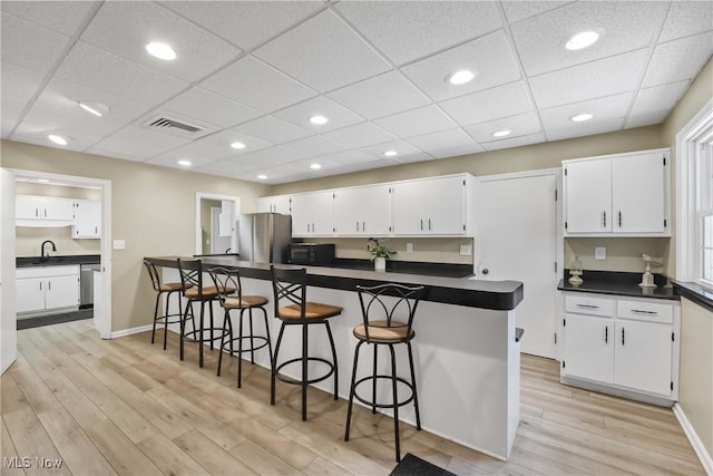 2021 King James Pkwy Unit 228, Westlake, OH 44145 - kitchen featuring dark countertops, appliances with stainless steel finishes, light wood-type flooring, white cabinets, and recessed lighting