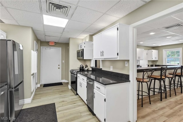 2021 King James Pkwy Unit 228, Westlake, OH 44145 - kitchen featuring stainless steel appliances, a paneled ceiling, light wood-type flooring, white cabinetry, and dark countertops