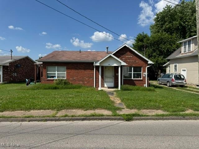 813 23rd St, Vienna, WV 26105 - view of front of home featuring brick siding and a front yard