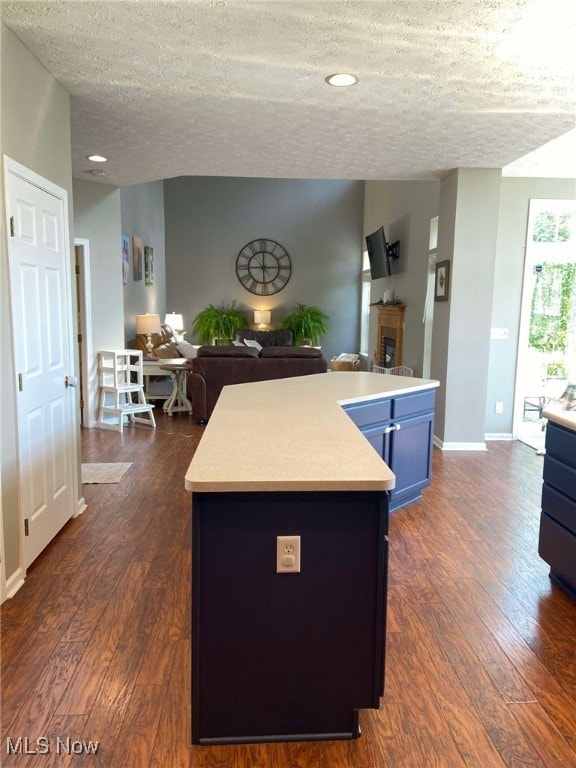7509 Galena Ave NW, Canal Fulton, OH 44614 - kitchen with blue cabinets, open floor plan, a textured ceiling, and light countertops