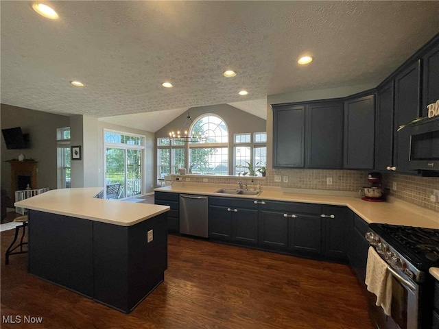 7509 Galena Ave NW, Canal Fulton, OH 44614 - kitchen with stainless steel appliances, a textured ceiling, lofted ceiling, dark wood-type flooring, and light countertops