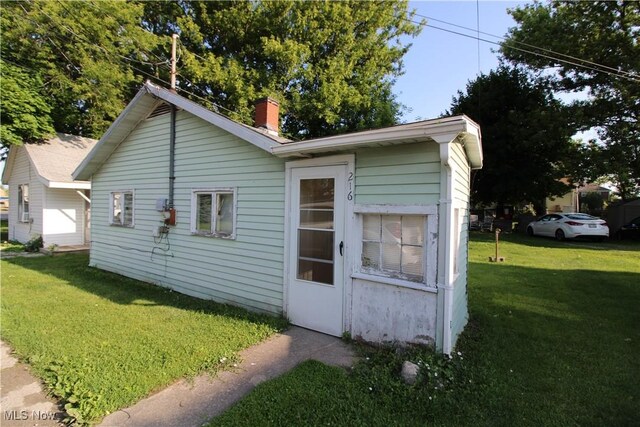 214 Fulton St, Port Clinton, OH 43452 - view of property exterior with a yard and a chimney