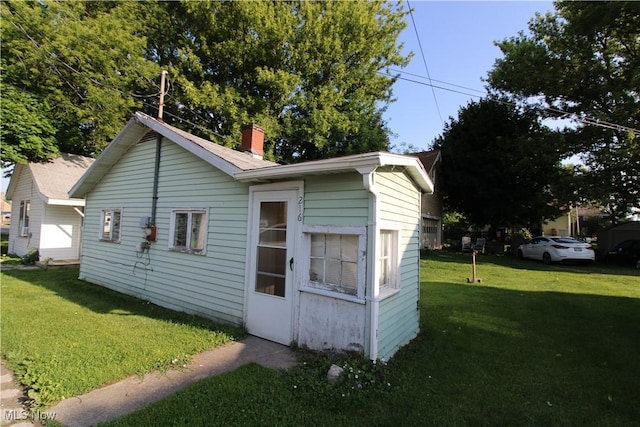 214 Fulton St, Port Clinton, OH 43452 - view of property exterior featuring a lawn and a chimney