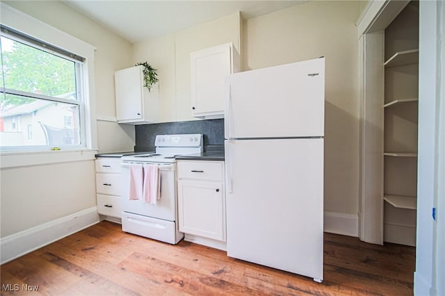 3006 6th St SW, Canton, OH 44710 - kitchen featuring white appliances, dark countertops, light wood-style floors, white cabinets, and tasteful backsplash