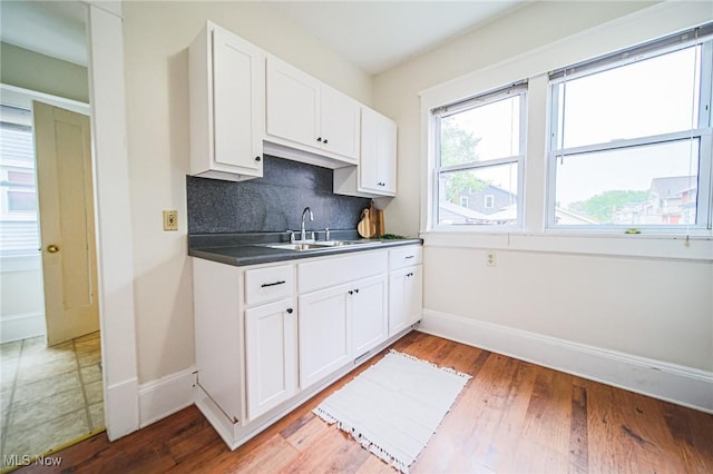 3006 6th St SW, Canton, OH 44710 - kitchen featuring white cabinetry, decorative backsplash, and light wood-style flooring
