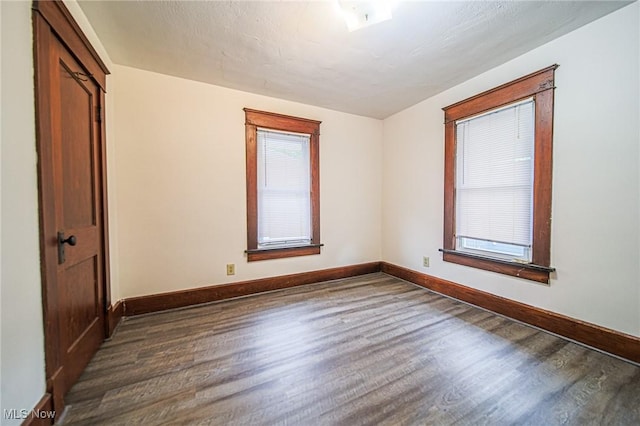 3006 6th St SW, Canton, OH 44710 - spare room featuring dark wood-style flooring and baseboards