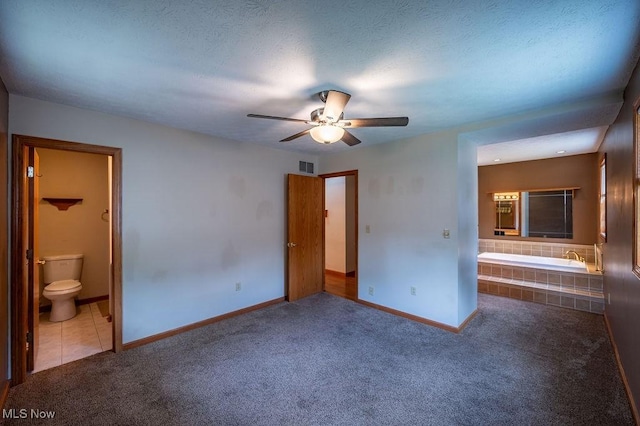 1565 Lois St, Belpre, OH 45714 - unfurnished bedroom featuring connected bathroom, carpet, and a ceiling fan