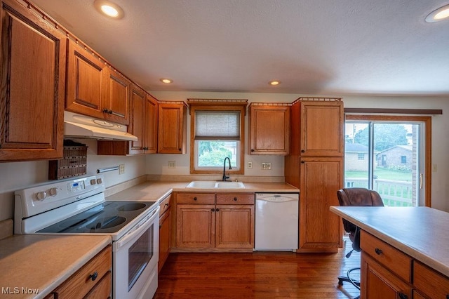 1565 Lois St, Belpre, OH 45714 - kitchen with white appliances, under cabinet range hood, dark wood-style flooring, brown cabinetry, and recessed lighting