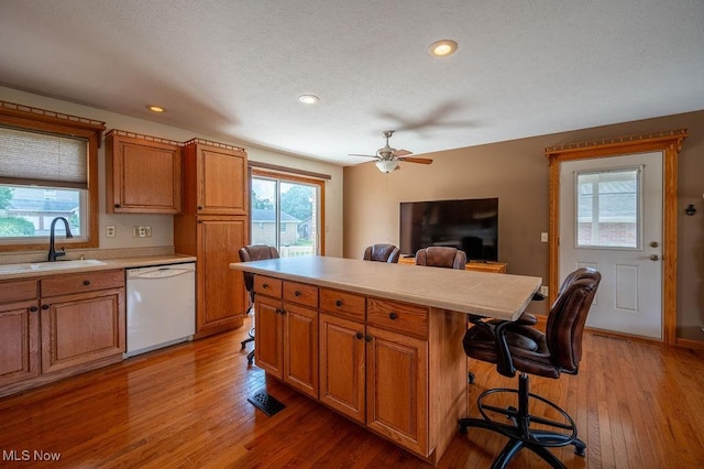 1565 Lois St, Belpre, OH 45714 - kitchen featuring white dishwasher, light wood-style flooring, a kitchen bar, healthy amount of natural light, and recessed lighting