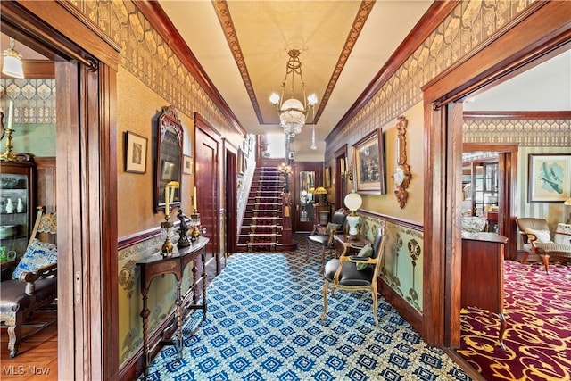 10921 Wade Park Ave, Cleveland, OH 44106 - corridor featuring wallpapered walls, stairs, a chandelier, and crown molding