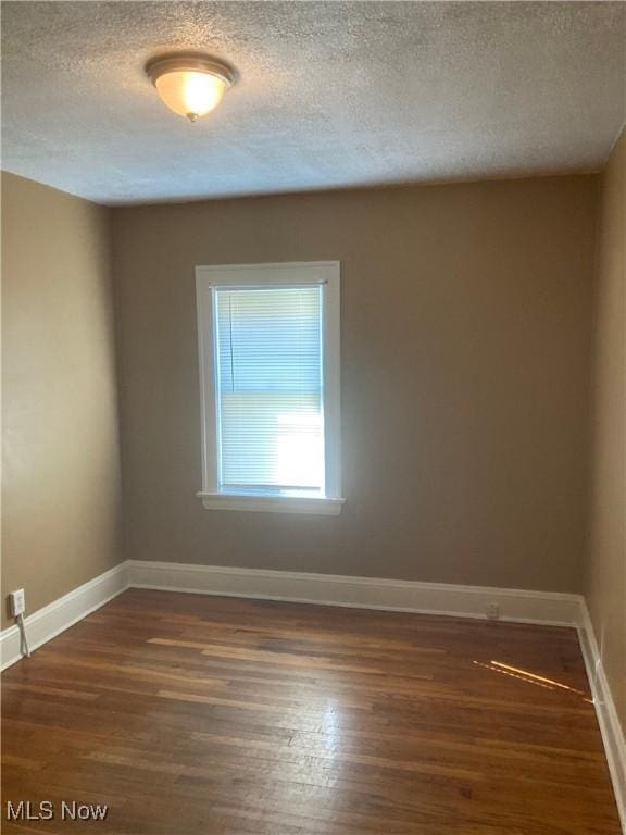 7508 Theota Ave, Parma, OH 44129 - spare room featuring dark wood finished floors and a textured ceiling