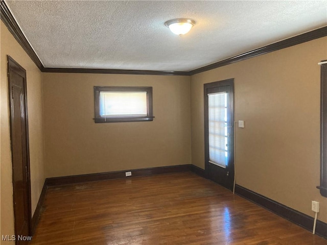 7508 Theota Ave, Parma, OH 44129 - empty room featuring crown molding, a textured ceiling, dark wood-style floors, and plenty of natural light