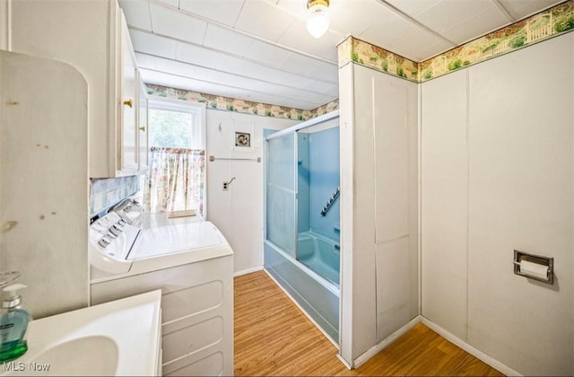 1016 W 55th St, Ashtabula, OH 44004 - bathroom with wood finished floors, enclosed tub / shower combo, and washer / clothes dryer