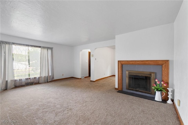 3788 Manchester Rd, Coventry, OH 44319 - unfurnished living room with carpet floors, arched walkways, and a fireplace