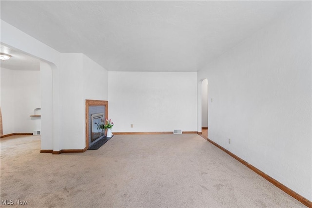 3788 Manchester Rd, Coventry, OH 44319 - unfurnished living room featuring arched walkways, carpet, and a fireplace with flush hearth