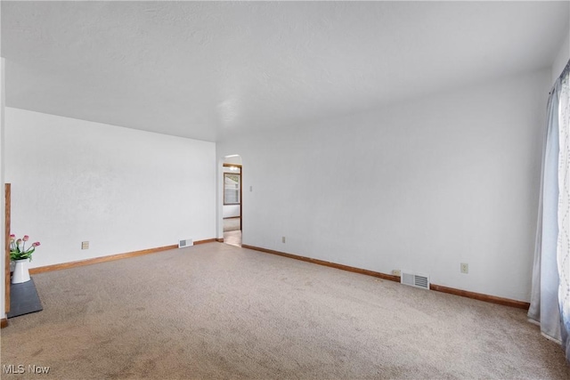 3788 Manchester Rd, Coventry, OH 44319 - unfurnished room featuring arched walkways, carpet flooring, and plenty of natural light