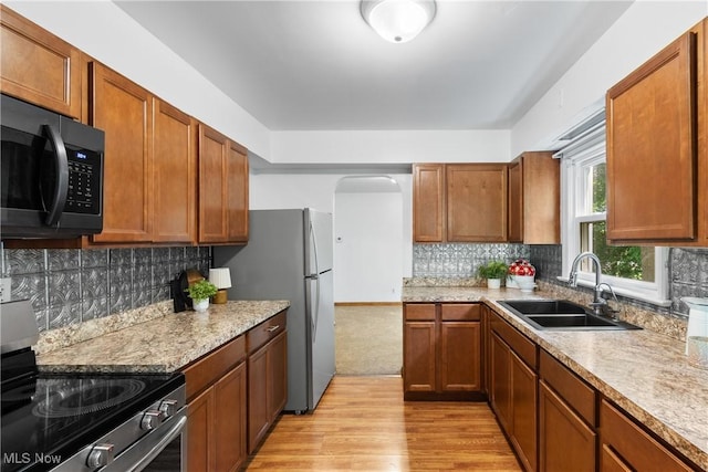 3788 Manchester Rd, Coventry, OH 44319 - kitchen with black microwave, stainless steel electric range oven, light wood-style flooring, and brown cabinets