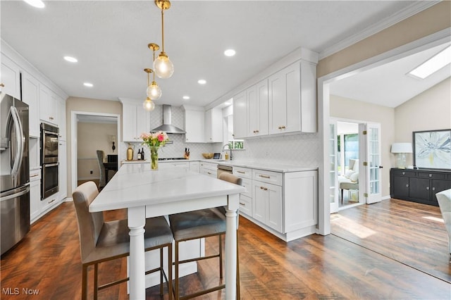 195 Sleepy Hollow Dr, Amherst, OH 44001 - kitchen featuring stainless steel appliances, wall chimney range hood, backsplash, white cabinets, and light countertops