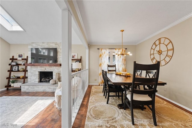 195 Sleepy Hollow Dr, Amherst, OH 44001 - dining room with wood finished floors, a skylight, a chandelier, a stone fireplace, and ornamental molding
