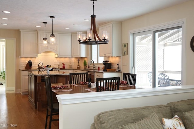 31382 Saint Andrews, Westlake, OH 44145 - kitchen featuring an island with sink, recessed lighting, hardwood / wood-style flooring, tasteful backsplash, and white cabinetry