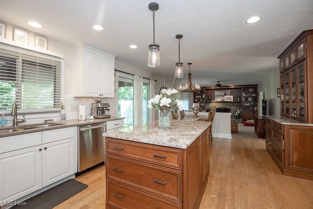 31382 Saint Andrews, Westlake, OH 44145 - kitchen with stainless steel dishwasher, a ceiling fan, a center island, backsplash, and light wood finished floors