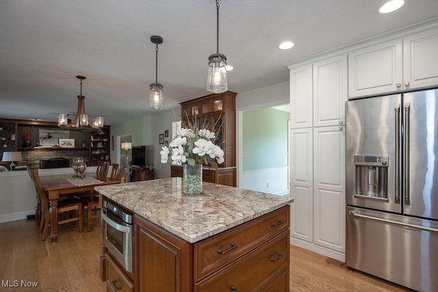 31382 Saint Andrews, Westlake, OH 44145 - kitchen featuring stainless steel appliances, light wood-type flooring, white cabinetry, light stone countertops, and recessed lighting