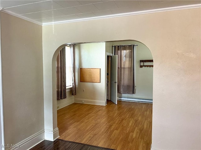 1030 Saint George St, East Liverpool, OH 43920 - spare room featuring arched walkways, a baseboard radiator, crown molding, and wood finished floors