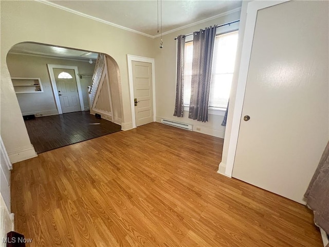 1030 Saint George St, East Liverpool, OH 43920 - spare room featuring arched walkways, ornamental molding, light wood-style flooring, and a baseboard radiator