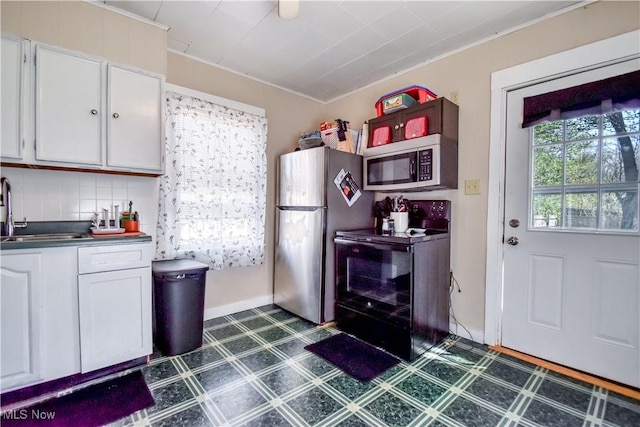 37 S Cedar St, Geneva, OH 44041 - kitchen featuring appliances with stainless steel finishes, dark flooring, white cabinetry, dark countertops, and ornamental molding