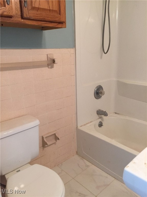 4211 Torrington Ave, Parma, OH 44134 - bathroom with tile walls, shower / bathtub combination, wainscoting, and marble finish flooring