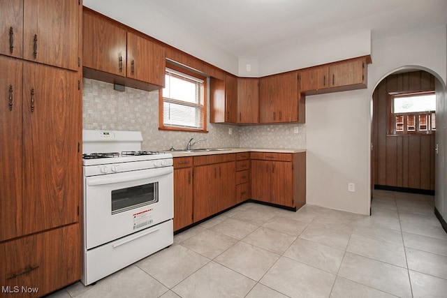 105 Tudor Ave, Bedford, OH 44146 - kitchen with gas range gas stove, backsplash, brown cabinetry, and light countertops
