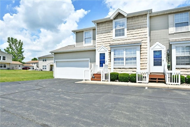 3189 Woodland Trl Unit A, Cortland, OH 44410 - view of front of house featuring asphalt driveway, a front lawn, and a garage