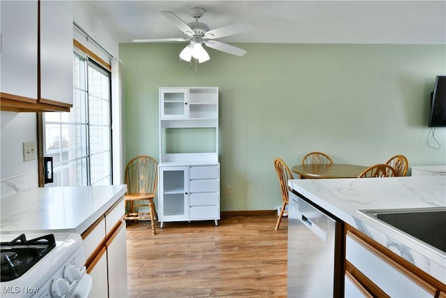 3189 Woodland Trl Unit A, Cortland, OH 44410 - kitchen featuring dishwasher, gas range oven, light countertops, light wood-style floors, and white cabinets