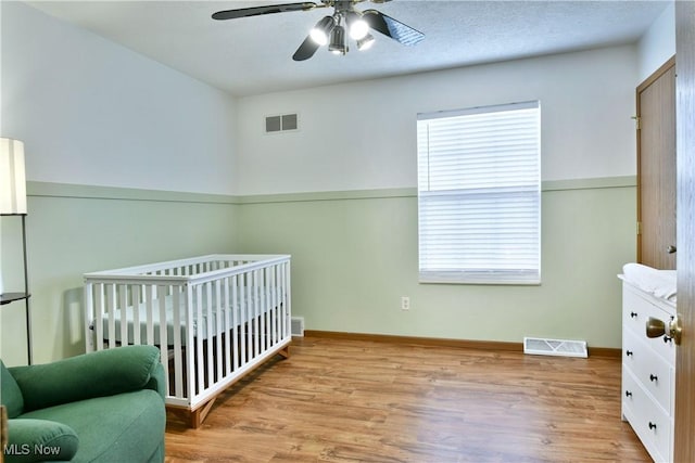 3189 Woodland Trl Unit A, Cortland, OH 44410 - bedroom featuring wood finished floors, a nursery area, and a ceiling fan