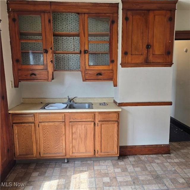 13013 Soika Ave, Cleveland, OH 44120 - kitchen featuring brown cabinets, light countertops, and glass insert cabinets