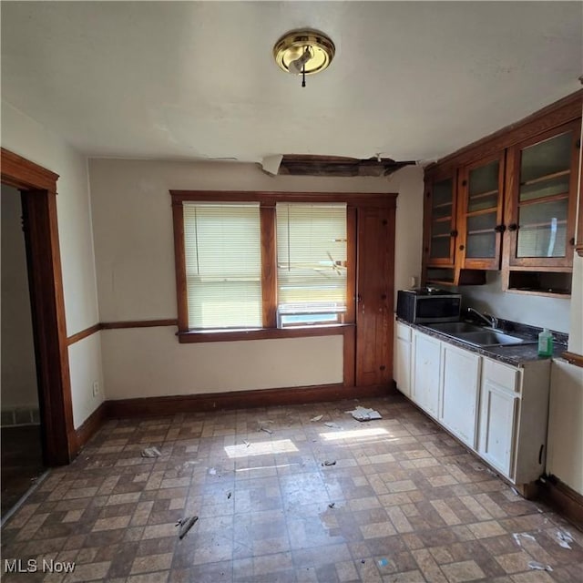 13013 Soika Ave, Cleveland, OH 44120 - kitchen featuring dark countertops, glass insert cabinets, and stainless steel microwave