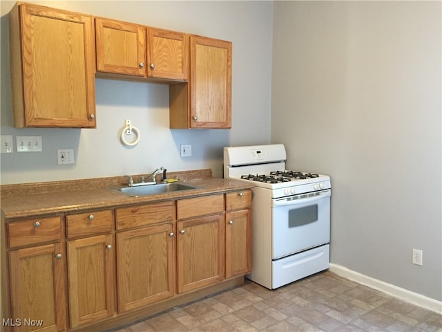 3439 Tuxedo Ave, Parma, OH 44134 - kitchen featuring white range with gas stovetop and brown cabinetry