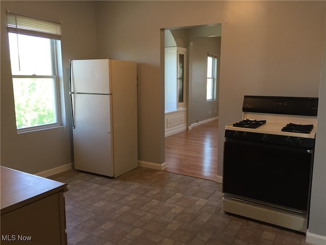 3439 Tuxedo Ave, Parma, OH 44134 - kitchen featuring range with gas stovetop, freestanding refrigerator, and plenty of natural light