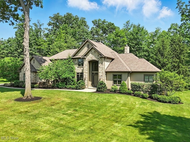 3880 Waterford Ct, Orange, OH 44122 - french country inspired facade featuring stone siding, a front yard, a chimney, and a shingled roof