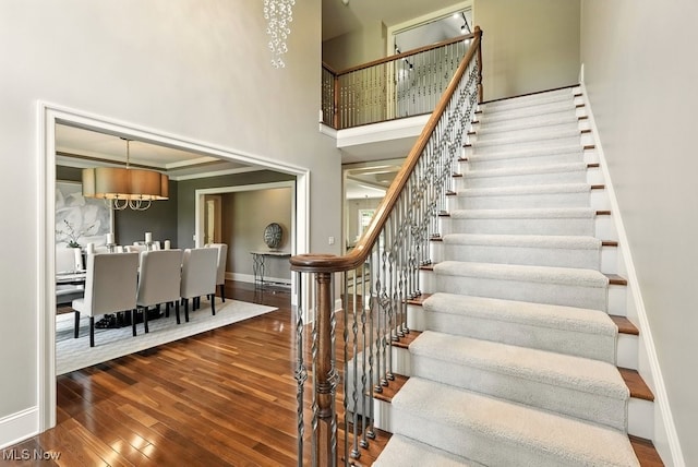 3880 Waterford Ct, Orange, OH 44122 - stairway featuring hardwood / wood-style floors, a chandelier, and a towering ceiling