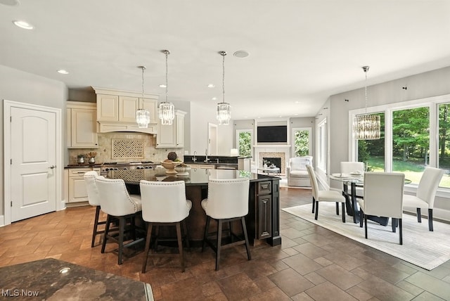 3880 Waterford Ct, Orange, OH 44122 - kitchen featuring a chandelier, decorative backsplash, a center island, cream cabinets, and decorative light fixtures