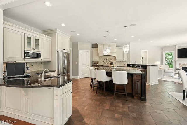 3880 Waterford Ct, Orange, OH 44122 - kitchen featuring stainless steel appliances, a peninsula, tasteful backsplash, a kitchen bar, and recessed lighting