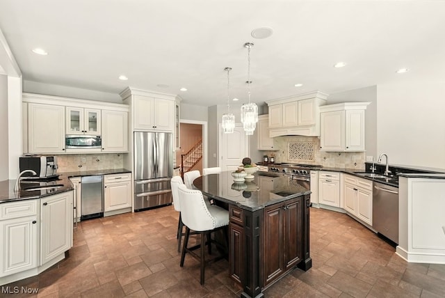 3880 Waterford Ct, Orange, OH 44122 - kitchen featuring stainless steel appliances, stone finish floors, decorative backsplash, a breakfast bar, and a kitchen island