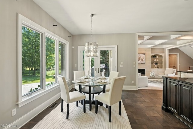 3880 Waterford Ct, Orange, OH 44122 - dining area with healthy amount of natural light, a chandelier, built in features, a fireplace, and beam ceiling