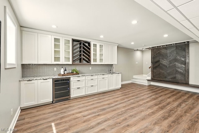 3880 Waterford Ct, Orange, OH 44122 - indoor wet bar with wine cooler, light wood-type flooring, recessed lighting, and backsplash