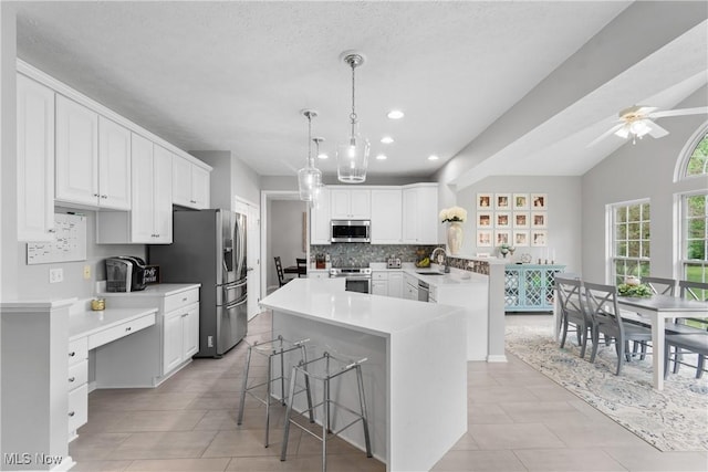 7605 Diamondback Ave NW, Canal Fulton, OH 44614 - kitchen featuring stainless steel appliances, a peninsula, tasteful backsplash, white cabinetry, and recessed lighting
