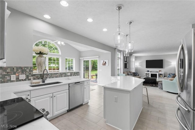 7605 Diamondback Ave NW, Canal Fulton, OH 44614 - kitchen with appliances with stainless steel finishes, open floor plan, white cabinets, decorative backsplash, and light countertops