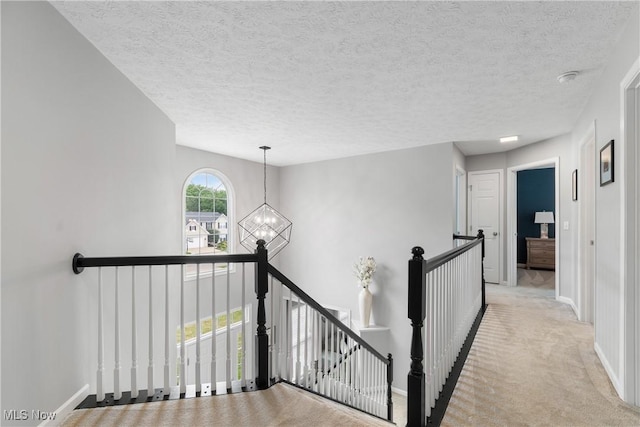 7605 Diamondback Ave NW, Canal Fulton, OH 44614 - hall featuring an upstairs landing, a chandelier, carpet, and a textured ceiling