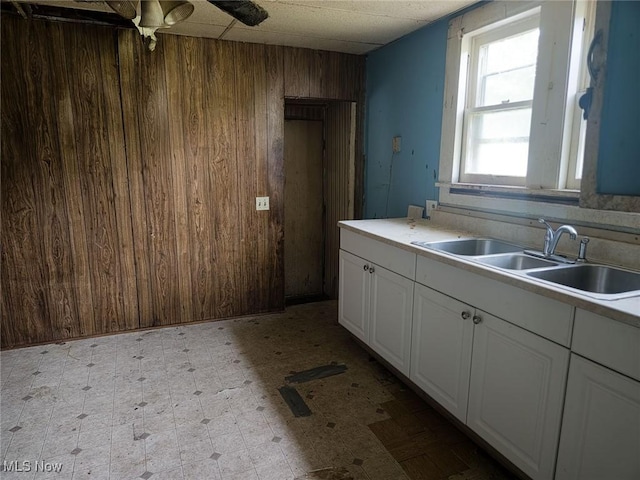 427 N 5th St, Cambridge, OH 43725 - kitchen with wooden walls, light floors, white cabinetry, light countertops, and ceiling fan